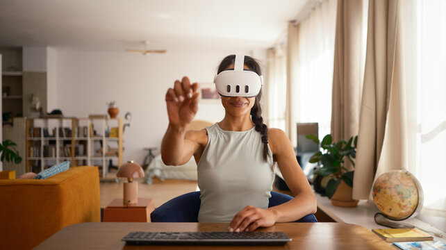 Smiling woman wearing VR glasses at home