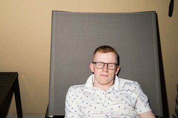Nerdy man napping on a lounge chair