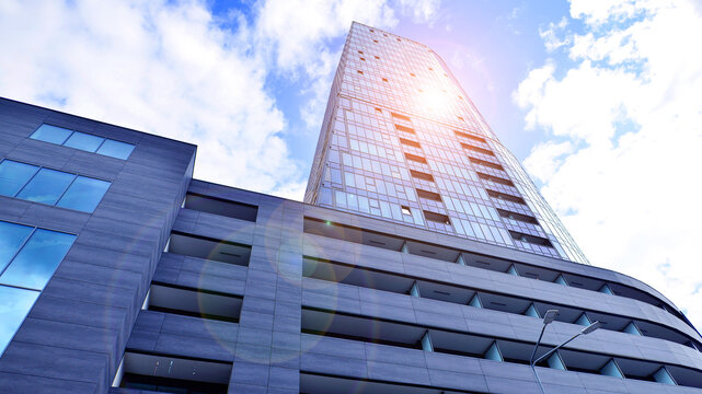 Looking up blue modern office building. The glass windows of building with aluminum framework. - Powered by Adobe