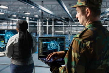 Close up of army tech expert in data center conducting threat simulations using AI networks. Server...