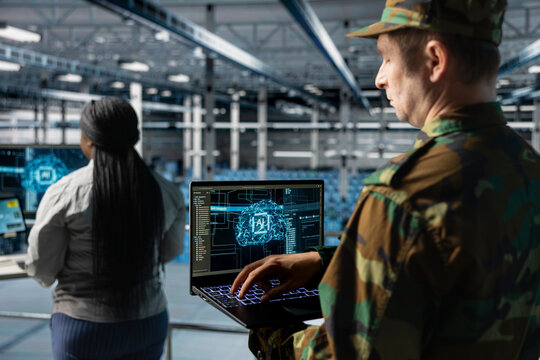 Close up of army tech expert in data center conducting threat simulations using AI networks. Server farm worker using artificial intelligence supporting digital operations