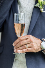groom holding a glas of sparkling rose at a wedding party