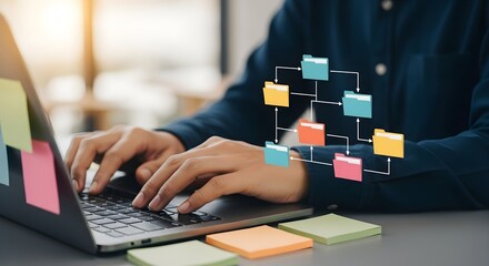 A person typing on a laptop with colorful sticky notes surrounding it