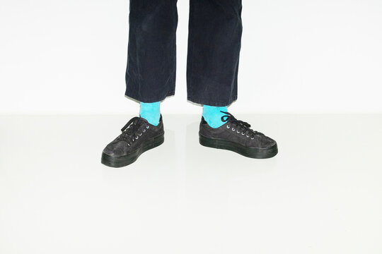 Person with blue socks and different pair sneakers trainers shoes