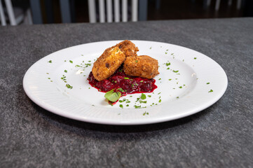 Crispy Fried Camembert Cheese with Sweet Cranberry Sauce on White Plate. Gourmet Appetizer Dish