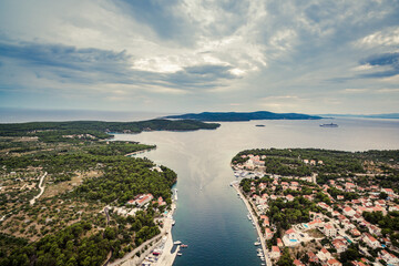 Aerial view of Milna town and marina on Brac island, Croatia, with sailboats, old stone houses, and Mediterranean landscape