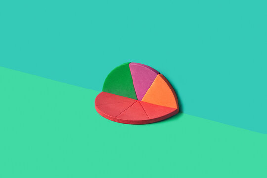 Flat foam pie chart halves on green background