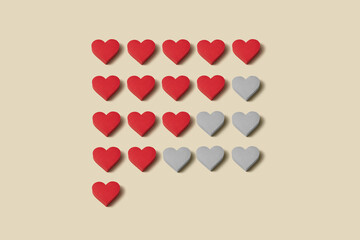 Paper hearts arranged in rating scale on beige
