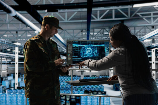 Server room army specialists deploying AI solutions across military systems to modernize defense infrastructure. Military server room colleagues enhancing tactical readiness by integrating AI