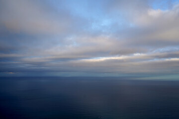 Ocean at sunset, with shadows and light on the clouds