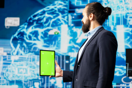 Surrounded by digital data and AI brain systems, businessman navigates virtual intelligence with a green screen on device. Using automation platforms for modern strategy and innovation.