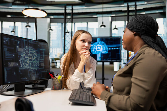 Young employee at desk pleading with AI tech startup manager for time off from work. Worker seeking help from artificial intelligence company team leader in professional workspace