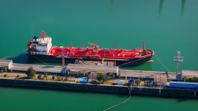 LPG shipping tanker moored at gas terminal, drone view of liquefied energy logistics chain