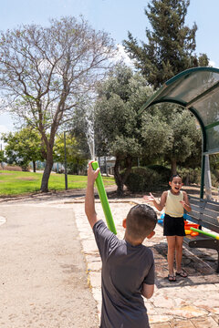 Kids Having Fun With Water Toys at a Park on a Sunny Afternoon