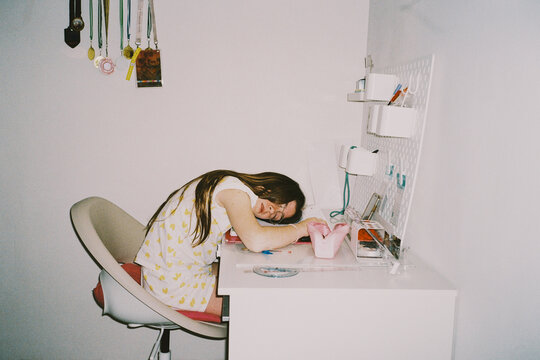Student asleep on homework desk
