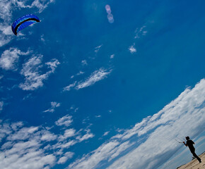 A person is kite surfing on a sunny day.