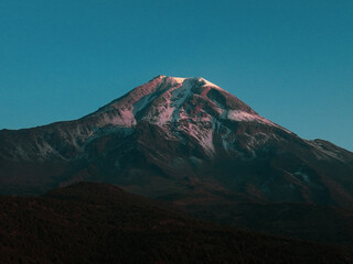 defaultPico de Orizaba at dawn with vibrant colors, highlighting the mountain&rsquo;s majestic landscape and its vital role in shaping surrounding watersheds and ecosystems.