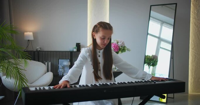 Exhausted child leaning on electronic keyboard after intense piano session. Practicing music at home