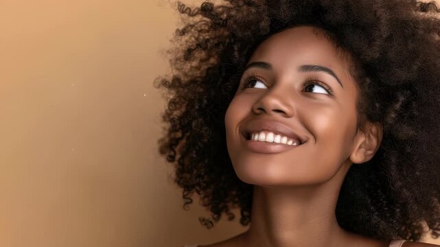 A portrait showcases a youthful woman with beautiful curly hair, smiling, and looking towards the upper left. The neutral-colored background creates a serene and natural aesthetic, highlighting her ra