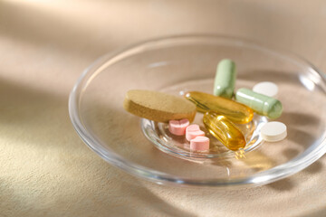 Assorted vitamins and supplements in a glass dish promoting health