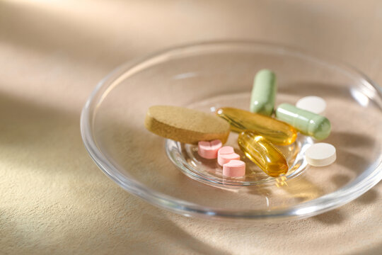 Assorted vitamins and supplements in a glass dish promoting health