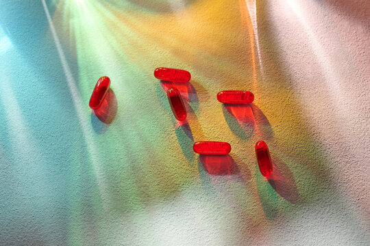 Aesthetic arrangement of red capsules on a textured surface