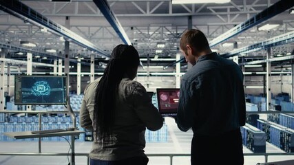 Team of server room technicians alerted by warning message on laptop causing infrastructure slowdowns. Teamworking data center colleagues see malfunction popup caused by software errors, camera A - Powered by Adobe