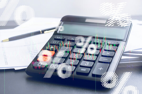 Calculator with percentage symbols and stock market chart overlay. Concept of interest rates with loan calculation, mortgage, finance, and economic analytics.