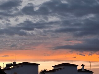 Colorful sunset sky illuminating rooftops over a tranquil evening landscape in a serene neighborhood