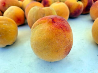 Ripe peaches displayed at a vibrant farmers market in Spain during the summer harvest season
