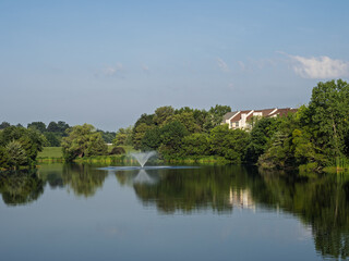 Community lake with fountain and houses reflected in Ashburn Village, Virginia