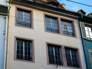 Old residential building in France with worn window frames and a patch of damaged paint suggesting abandonment or prolonged lack of maintenance