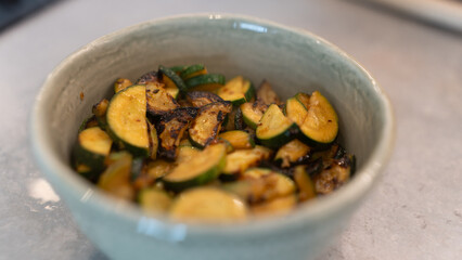 Golden fried zucchini with aromatic herbs served in a rustic bowl. Healthy vegetable dish perfect for food photography, vegan recipes, and clean eating content