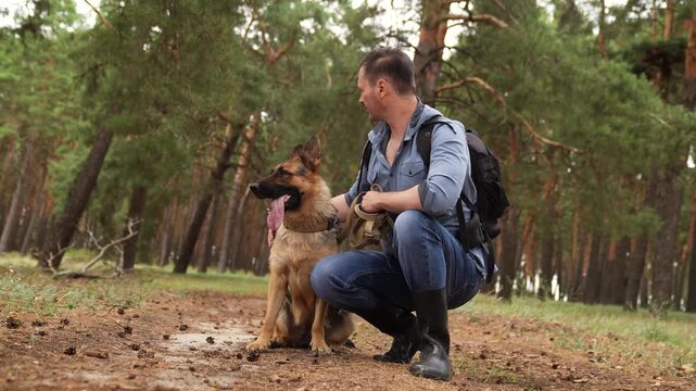 Man bonding with German Shepherd in woodland, Relaxation in the forest with pet, Dog and owner looking content during hike, Adventure buddies: man and dog outdoors, Calm moment in nature for two