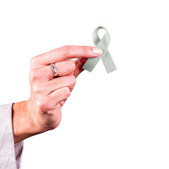 Woman’s hand holding a gray ribbon over a transparent background. Symbol of brain cancer and...