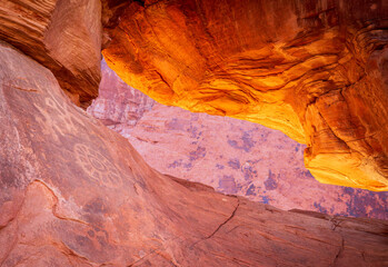 Petrolglyphs on the dramatic red sandstone formation of Atlatl Rock with natural arch in Valley of Fire state park Nevada