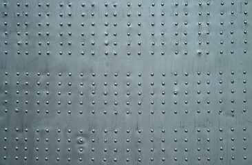 Abstract metal background. Old weathered silver metallic background. Vintage metal texture with rivets and bolts. Sheathing old plane. Old metal texture. High quality photo