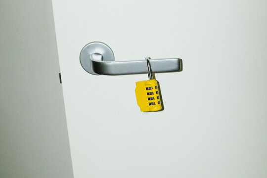 Yellow lock / padlock in the door with hard direct flashlight