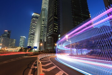 The highway car rainbow light trails of modern city buildings