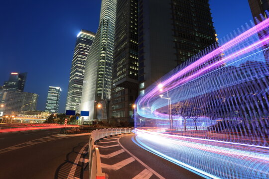 The highway car rainbow light trails of modern city buildings
