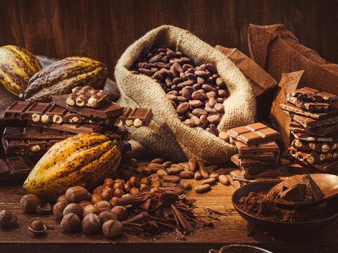 Chocolate production with cocoa beans and bars on wooden table