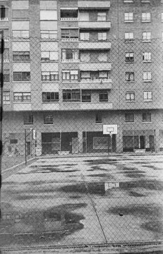 Fototapeta 35 mm B&W film photo of cityscape with buildings and basketball court
