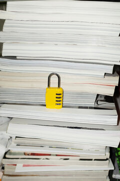 Yellow lock / padlock in bookshelf with hard direct flashlight