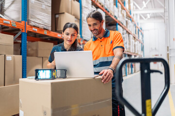 Logistic workers using laptop and barcode scanner in warehouse
