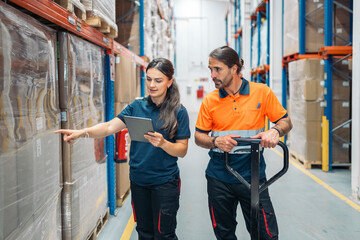 Logistic workers checking goods with digital tablet in warehouse
