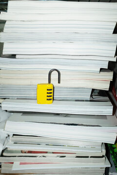 Yellow lock / padlock in bookshelf with hard direct flashlight