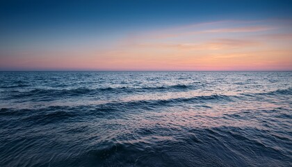 Obraz premium calm ocean sunset horizon with gentle waves and pastel sky colors creating a serene atmosphere for relaxation and nature lovers coastal landscape photography