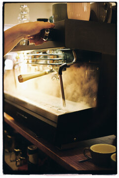 Barista using coffee machine at cafe