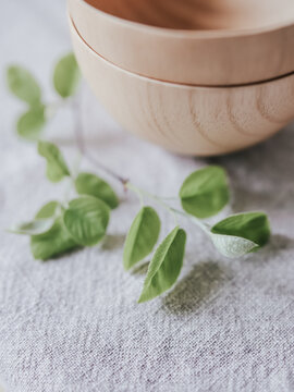 Wooden bowls with leafy twig on fabric