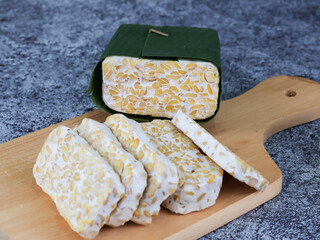 Sliced of Tempeh or tempe on cutting board. Tempeh is a traditional Indonesian food made from fermented soy beans. 